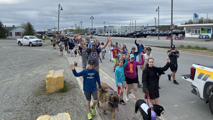 plusieurs personnes marchent avec leur chien