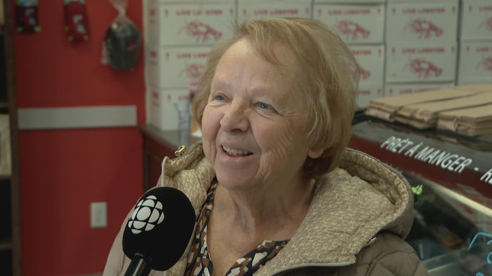 Une femme sourit, en entrevue, dans une poissonnerie.