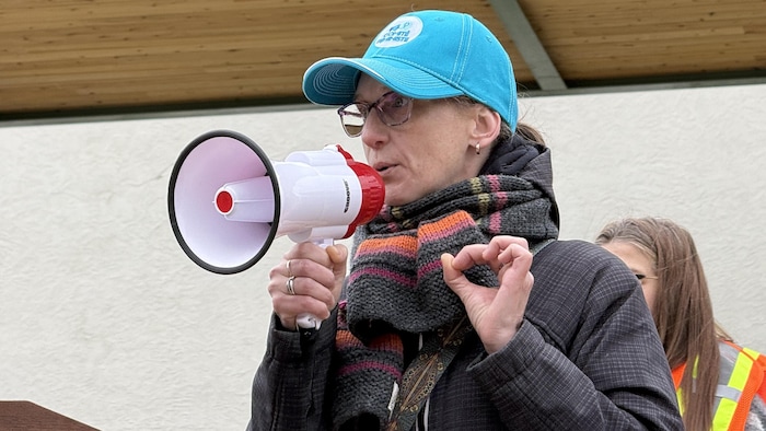 Une femme parle dans un mégaphone en public.
