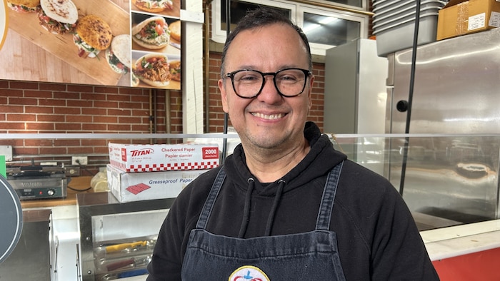 Ulises Aragon devant son comptoir de sandwichs au Marché de Moncton.
