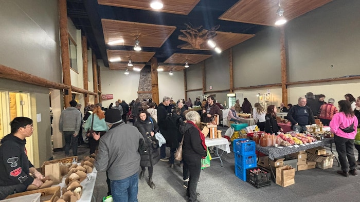 Des commerçants et des clients dans un marché de fermiers.