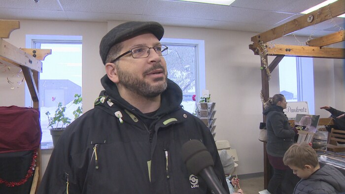 Un homme accorde une entrevue au marché des fermiers de Saskatoon.