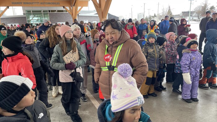 Plusieurs enfants rassemblés à l'extérieur.   