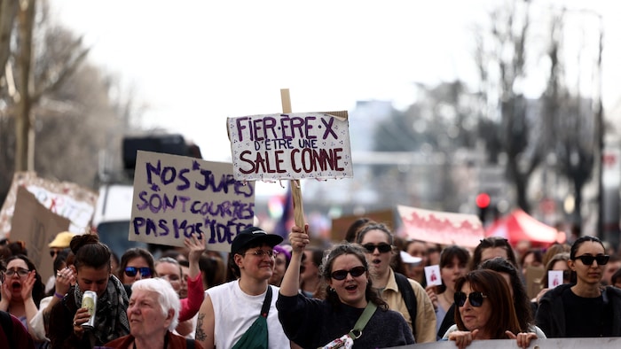 Une manifestante brandit une pancarte qui porte la mention « Fière d'être une sale conne » lors d'une marche organisée à l'occasion de la Journée internationale des droits des femmes à Lyon, dans le centre de la France, le 8 mars 2026. 