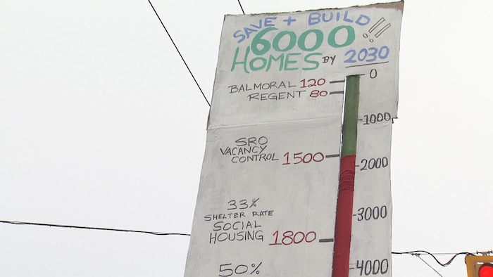 Un thermomètre sur une affiche indique comment faire baisser la température de la crise du logement, à Vancouver, en Colombie-Britannique, le 4 mai 2024.

