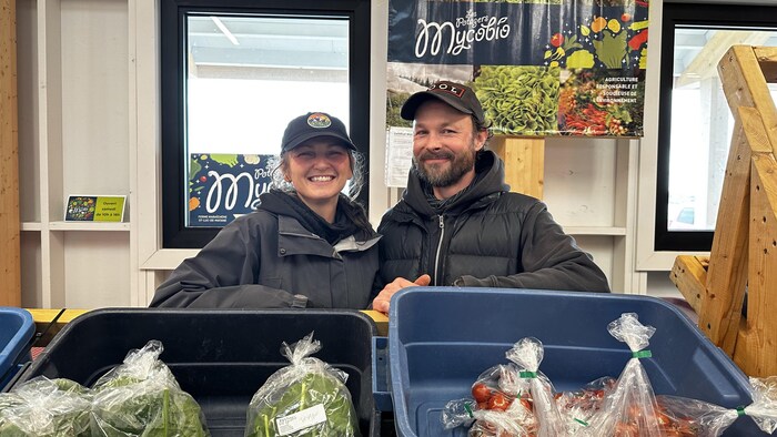 Marie-Hélène Côté et Denis Morais devant leur kiosque de légumes.
