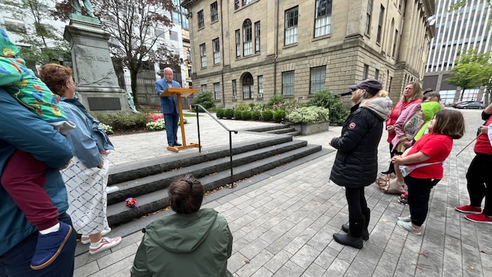 Un groupe de personnes se réunit autour de Province House pour aborder les effets des TSAF.