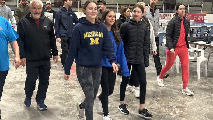 Des gens marchent dans un aréna.