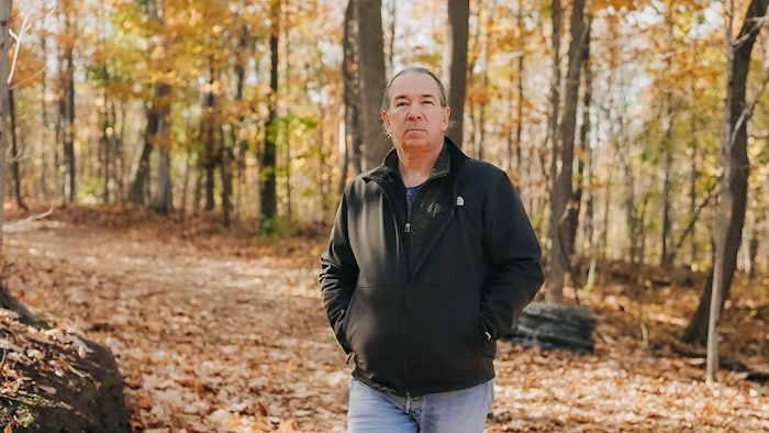 Marco Poulin dans un bois en automne.