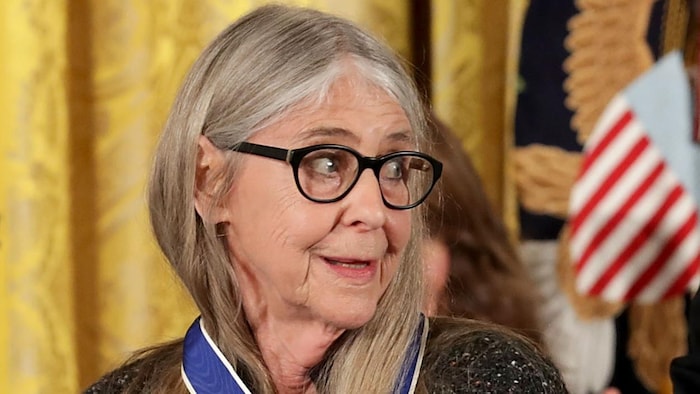 Margaret Hamilton se retourne, une médaille au cou.