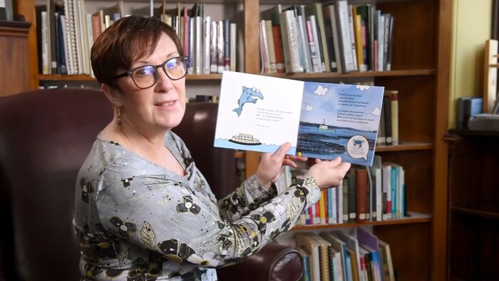 Margaret Johnson tient un livre pour enfants.