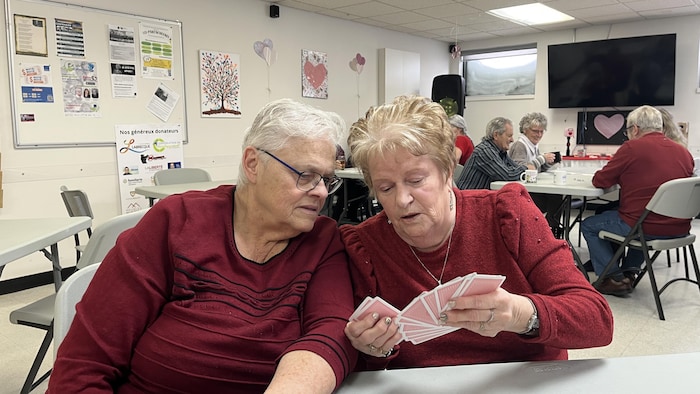 Deux femmes jouent aux cartes ensemble.