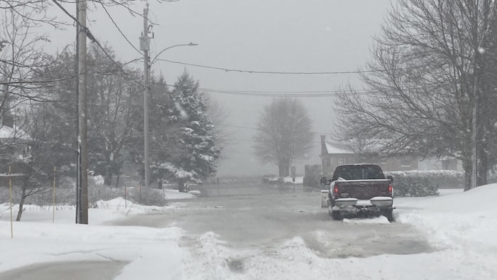 Une camionnette dans une rue inondée.