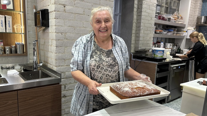 Maria Sotiropoulou dans une cuisine commerciale avec un gâteau.