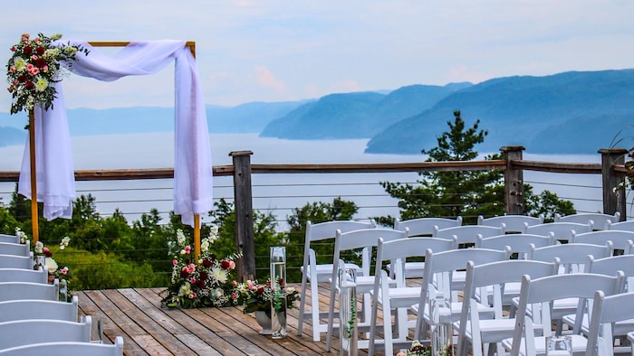 Des chaises sont placées devant une arche avec une rivière derrière.