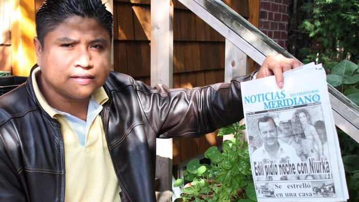 A man holds a newspaper.