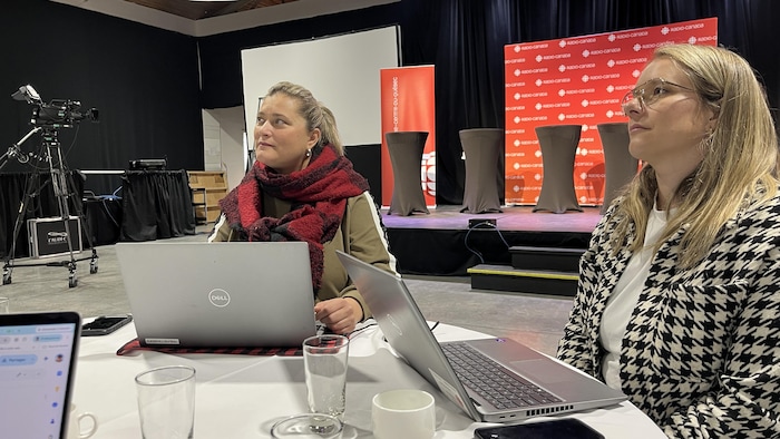 Les journalistes préparent le débat en ayant leurs ordinateurs portables sur une table.