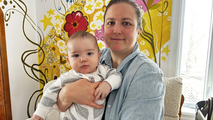 Un bébé dans les bras de sa mère. 