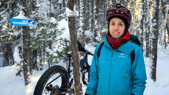 Marie-Hélène Harvey, la présidente du club de vélo Norcycle, dehors en hiver avec un casque à vélo sur la tête.