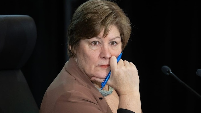 La commissaire Marie-Josée Hogue écoute, un stylo à la main, l'air pensif.