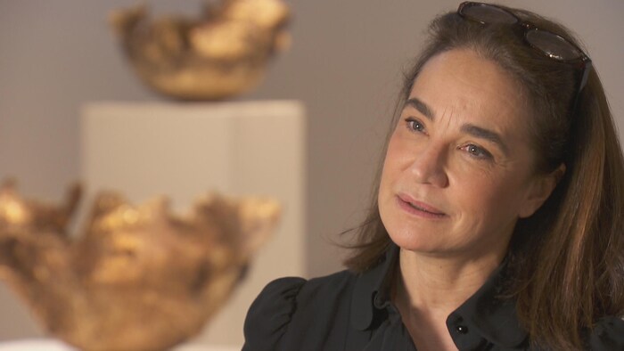 La sculptrice Marie Khouri avec deux de ses sculptures en arrière-plan.