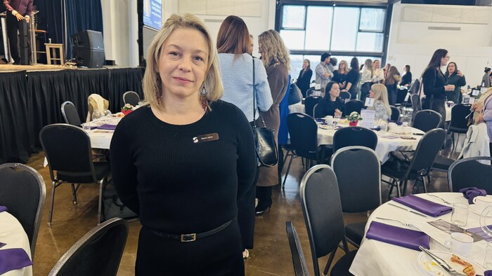 Marie Litalien debout dans une salle devant d'autres personnes.