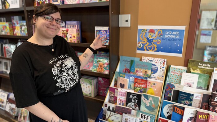 Marie-Soleil Malo désigne de la main des livres. 