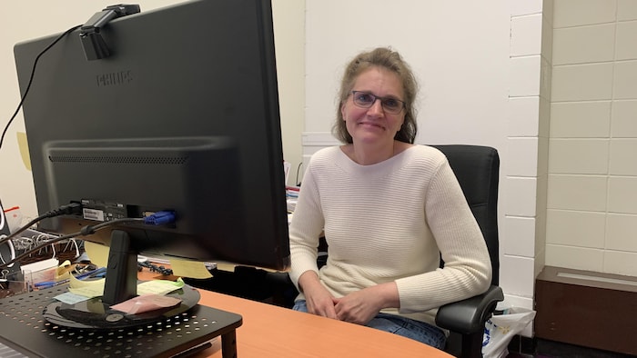 Mariella Collini, assise à son bureau, pose pour la caméra.