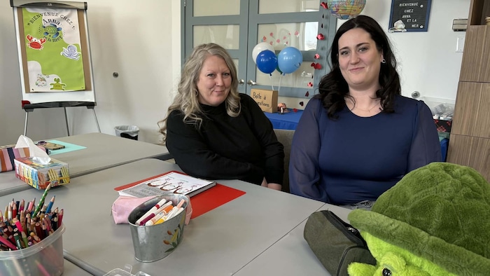 Deux femmes assise pour la photo. 