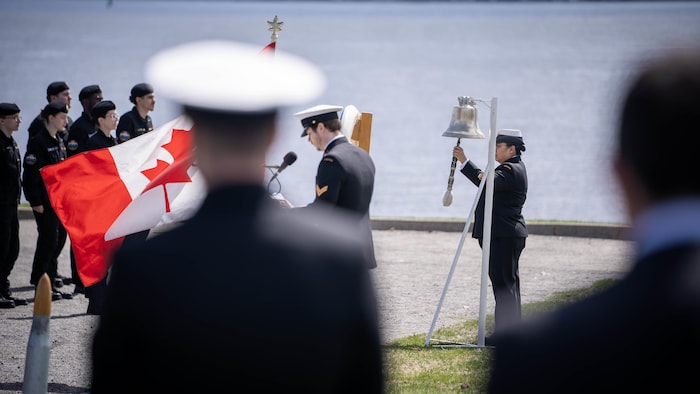 Des membres de la Marine royale canadienne font sonner la cloche aux abords du fleuve Saint-Laurent à Trois-Rivières. 
