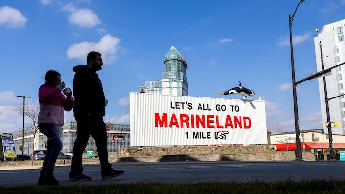 Des gens devant une enseigne de Marineland.