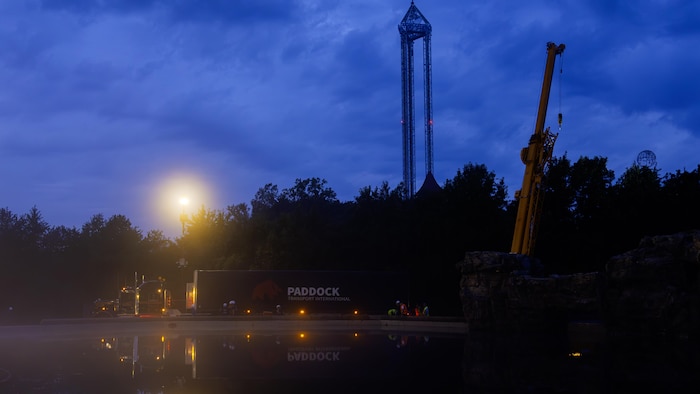 La pénombre et le brouillard tombent sur un bassin artificiel d’eau éclair par un spot. On y voit aussi un camion, une grue ainsi que la tour du parc Marineland.