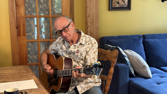 Un homme à la guitare dans une cuisine