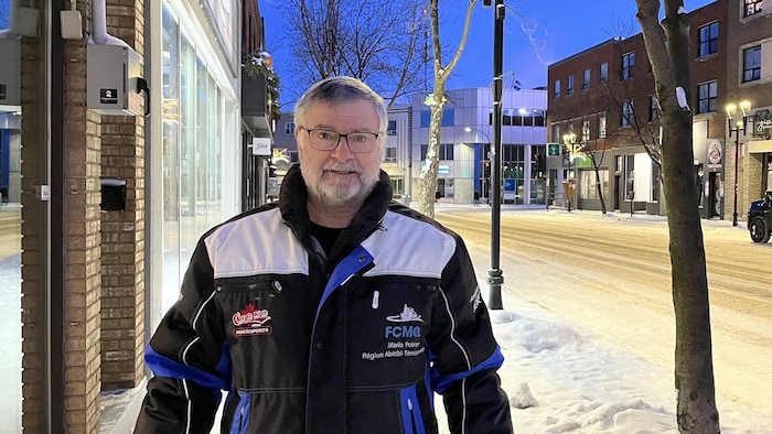 Mario Poirier porte un manteau de la Fédération des clubs de motoneigistes du Québec.