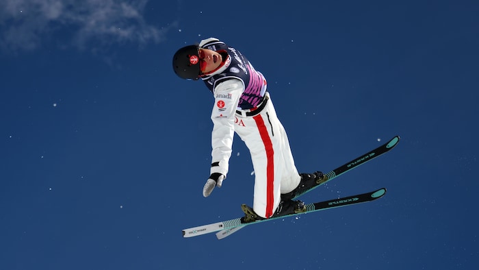 Une skieuse fait des figures dans les airs.