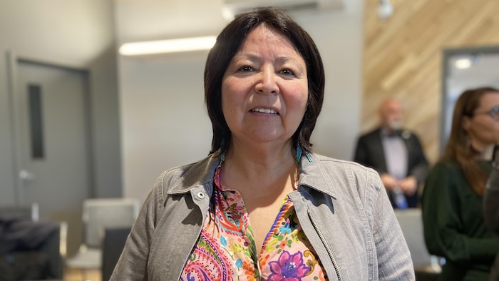 Une femme debout dans une salle pour se faire prendre en photo.