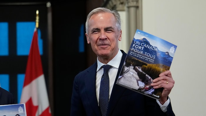 Le premier ministre du Canada, Mark Carney, tenant un exemplaire de la mise à jour économique.