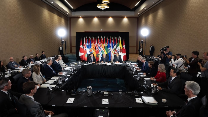 Dominic LeBlanc, Mark Carney et Rob Lantz, assis à la tête d'une table.