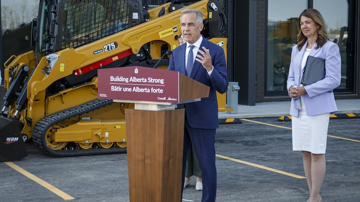 Le premier ministre, Mark Carney, au centre, et la première ministre de l'Alberta, Danielle Smith, font une annonce concernant le logement à Red Deer, en Alberta, le mercredi 29 juillet 2026.