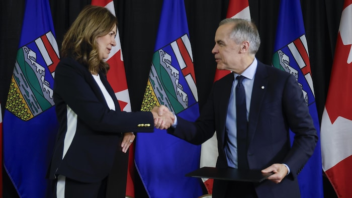 Mark Carney et Danielle Smith se serrent la main.