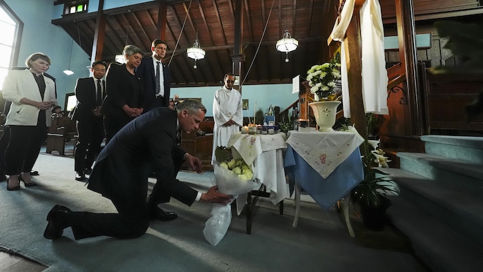 Mark Carney dépose des fleurs.