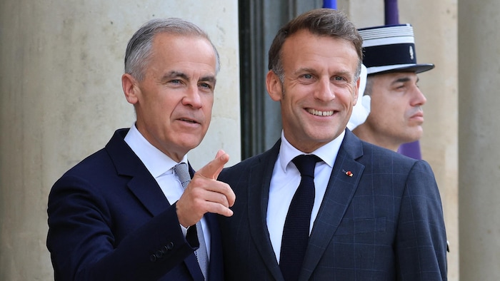 Emmanuel Macron accueille Mark Carney à l’entrée de l’Élysée.