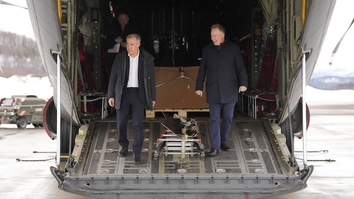 Le premier ministre du Canada, Mark Carney, et le secrétaire d'État à l'Approvisionnement en matière de défense, Stephen Fuhr, descendent d'un avion militaire.