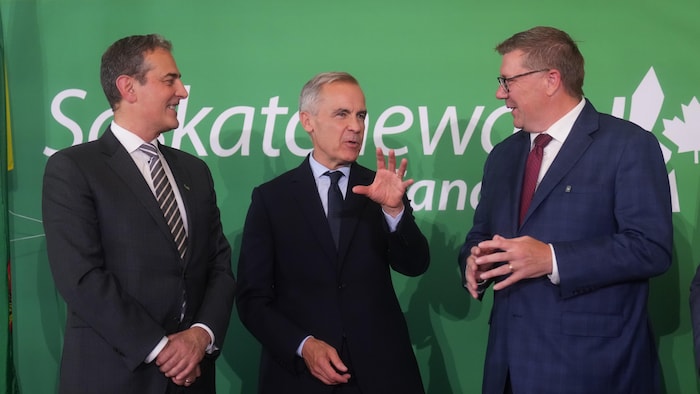Le premier ministre Mark Carney, au centre, s'entretient avec le premier ministre de la Saskatchewan, Scott Moe, à droite, et le PDG de Bell Canada, Mirko Bibic.