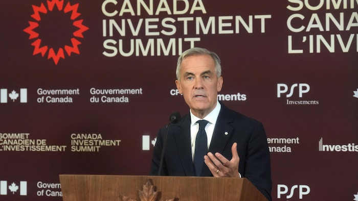 Mark Carney prononce un discours derrière un lutrin.
