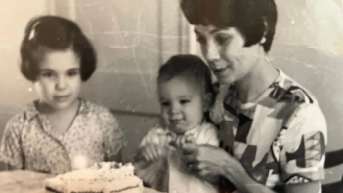 Mark Sutcliffe, enfant, fête un anniversaire avec sa mère et sa sœur. 