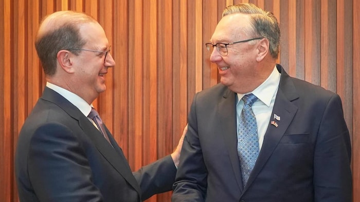 Le premier ministre de Terre-Neuve-et-Labrador, Tony Wakeham et l'ambassadeur du Canada aux États-Unis, Mark-Wiseman se regardent en se serrant la main. 
