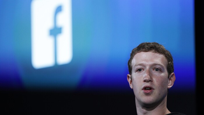Le fondateur de Facebook Mark Zuckerberg devant le logo de Facebook.