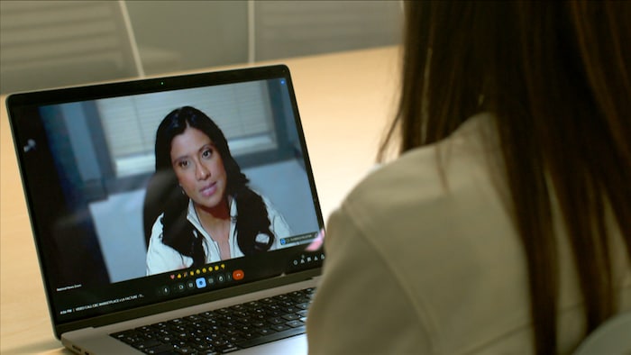 Le visage d'une femme apparaît sur l'écran d'un ordinateur.