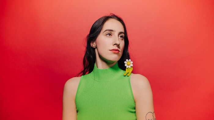 L'artiste Marlaena Moore devant un fond rouge.
